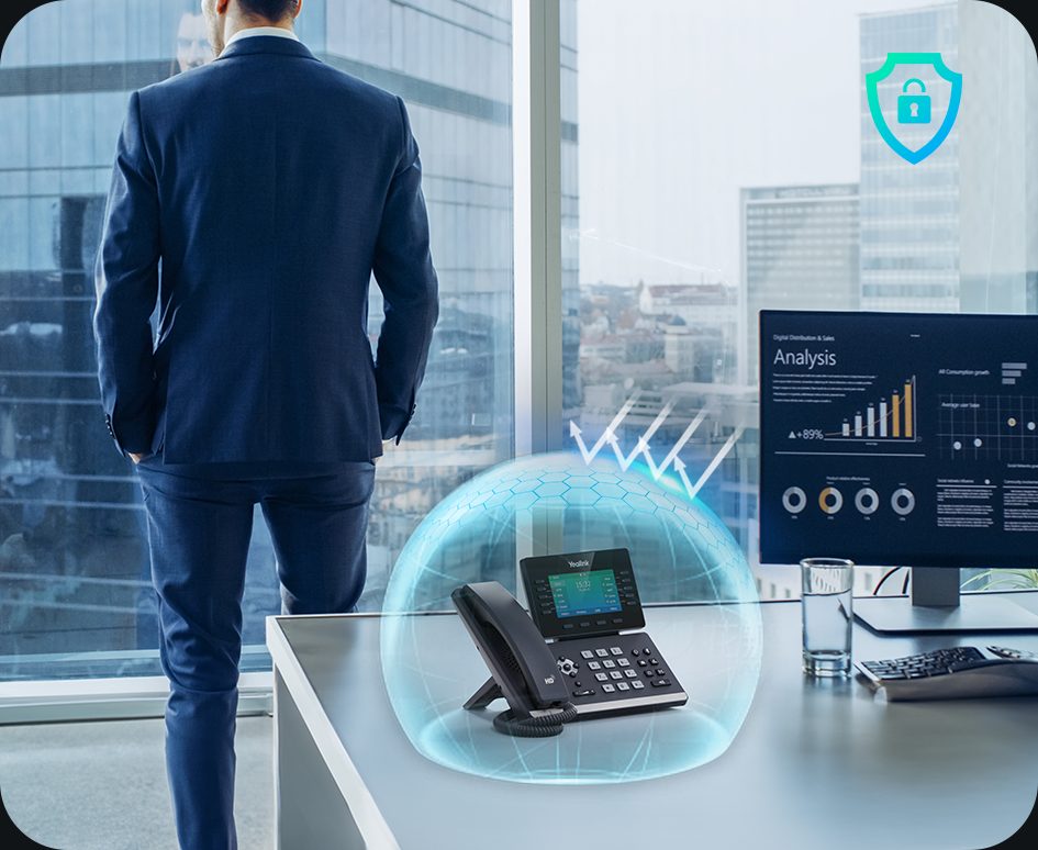 Yealink desk phone protected by a security shield in an office